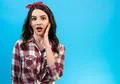 The portrait of the surprised woman on the blue background Photo