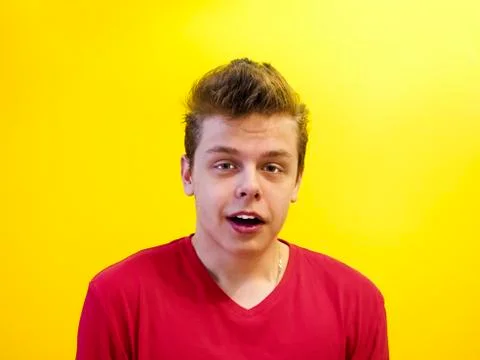 Portrait of a talking man in studio yellow background 스톡 사진