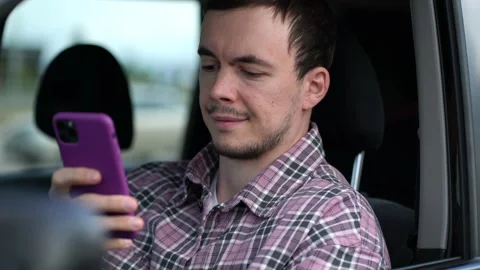 Portrait of a taxi driver checking an order by phone. Guy browsing social media Stock Footage 208871239