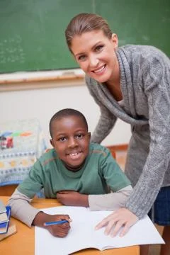 Portrait of a teacher explaining something to a smiling schoolboy Stock Photos
