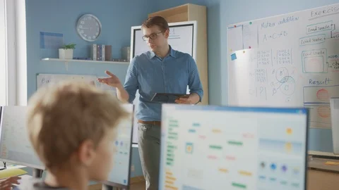 Portrait of Teacher Using Digital Tablet, Explains Lesson to Smart Children Stock Footage 119360550