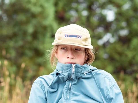 Portrait of teen boy looking off frame with hat and wind breaker Stock Photos