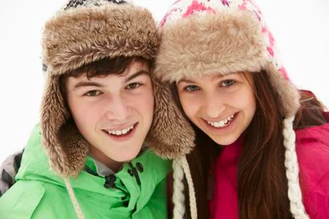 Portrait Of Teenage Couple In Snow Wearing Fur Hats Stock Photos