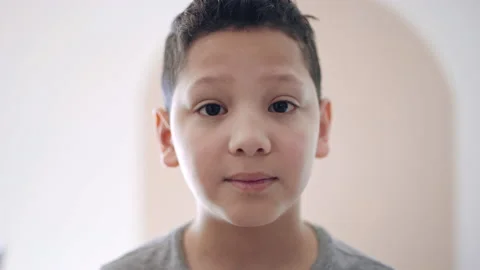 Portrait of ten year old hispanic boy with expectant, curious expression on face Video stock 194470877