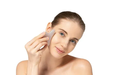 Portrait of tender young woman doing face massage with special cosmetic  tool Stock Image #195675181