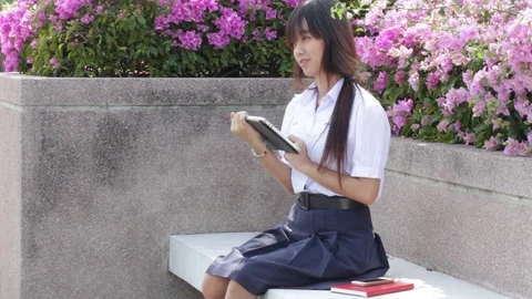 Portrait of thai high school student uniform beautiful girl using her tablet Stock Footage 70609837