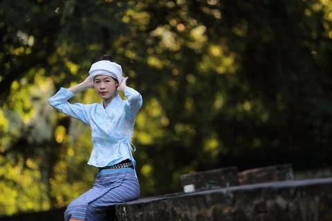 Portrait of thai young woman with traditional thai dress sit in thai temple w Stock Photos