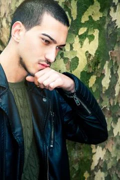 Portrait of thinking young man. A guy with a leather jacket with her hand nea Stock Photos