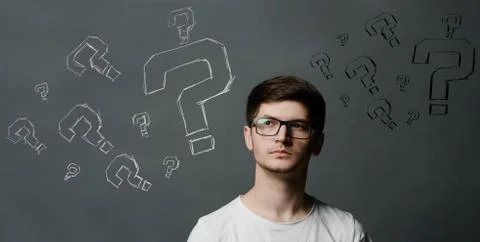 Portrait of thinkng young guy with question mark above his head. Stock Photos