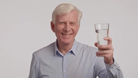 Portrait of thirsty gray haired senior man drinking clear water from glass. Stock Footage 263280174