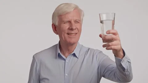 Portrait of thirsty gray haired senior man drinking clear water from glass. Stock Footage 263280199