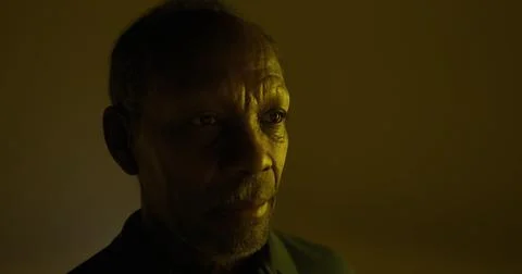 Portrait of a thoughtful elderly man in a dimly lit room Stock Illustration
