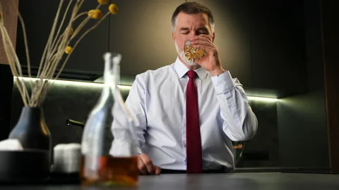 Portrait thoughtful senior man drinking whiskey in luxury interior Stock Footage 234650185