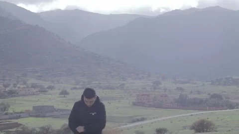 Portrait of Thoughtful Young Man in Epic Mountain Valley Stockbeeldmateriaal 332773179