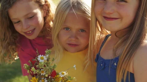 Portrait of three children with bunch of wild flowers in park. Stock Footage 43673501