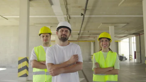 Portrait of Three construction workers stand inside a building under 스톡 동영상 348238099