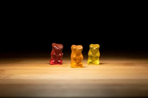 A portrait of three different colored gummi bears, the candy is standing on a Stock Photos