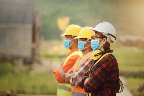 Portrait of three engineers on a construction site wearing face masks, Thaila Stock Photos