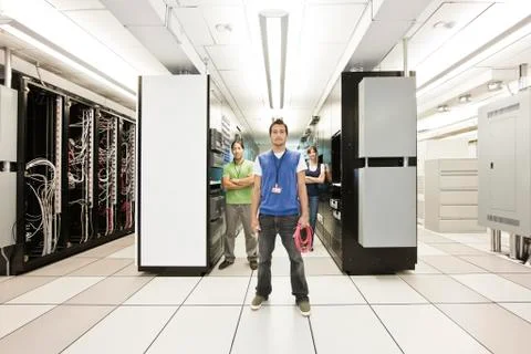 Portrait of three muli-ethnic technicians who work in a large computer server Stock Photos
