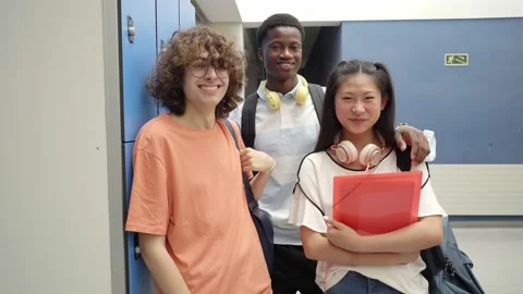 Portrait of three multiracial students looking at the camera smiling at a high Stock Footage 161380771