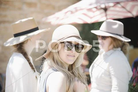 Portrait of three women wearing hats and sunglasses. Stock Photos