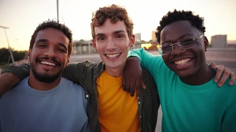 Portrait of three young multiracial men embracing and smiling looking at the Stock Footage 268294360