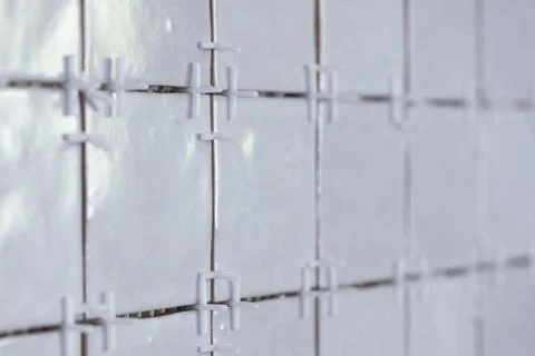A portrait of a tile wall under construction. The wall is being tiled with .. Stock Photos