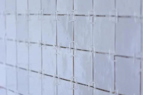A portrait of a tile wall under construction. The wall is being tiled with .. Stock Photos