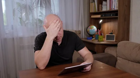Portrait of a tired, frustrated man working at home with a tablet. Stock Footage 307393930