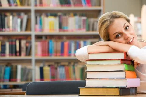 Portrait of tired student lying on the stack of books 스톡 사진