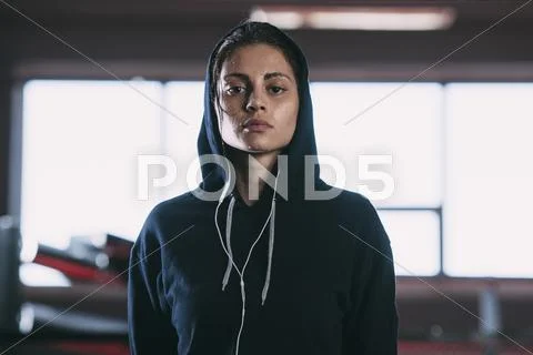 Portrait Of Tired Woman Wearing Hooded Shirt Standing At Gym