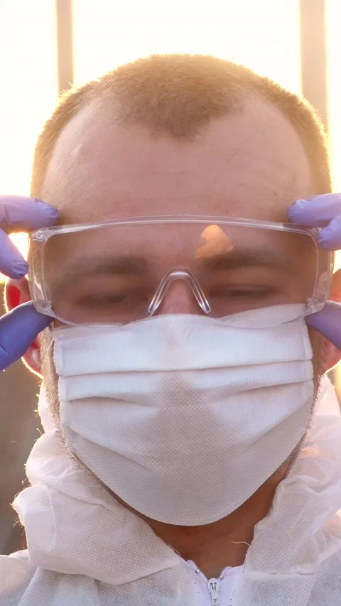 Portrait of tired young epidemiologist taking off hazmat suit and medical mask Stock Footage 302386835