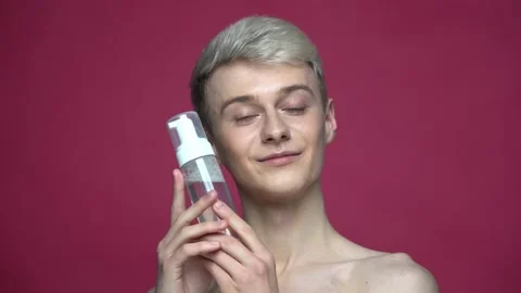 Portrait of topless guy holding bottle with skin care product 库存影片 156608918