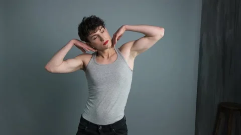 Portrait of a transgender with makeup posing on grey background. Medium shot Stock Footage 145814583