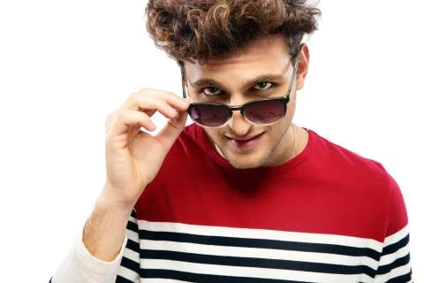 Portrait of a trendy man looking at the camera through sunglasses Stock-Fotos