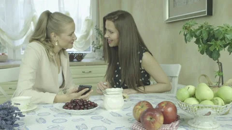 Portrait of two attractive smiling young women having tea at dining table Stock Footage 40132731
