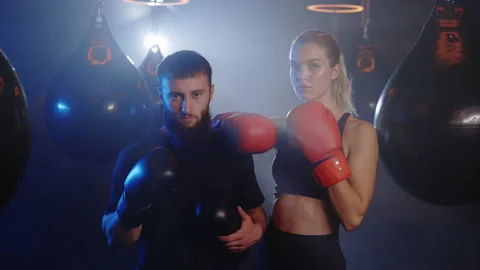 Portrait of the two boxing trainers standing in the gym wearing boxing gloves Stock Footage 205841379