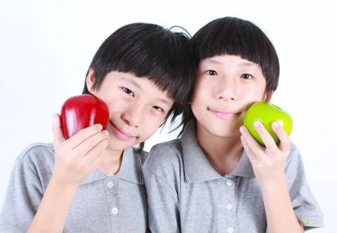 Portrait of two boys, twins holding red and green apples Stock Photos