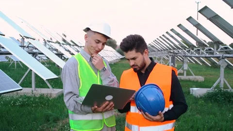 Portrait of two charismatic engineers learning the construction plan of a solar Stock Footage 140207199