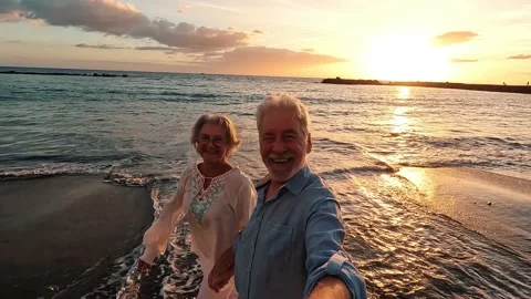 Portrait of two cute old persons having fun and enjoying together at the be.. 動画素材 224754719