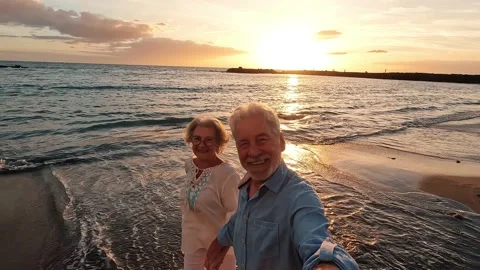 Portrait of two cute old persons having fun and enjoying together at the be.. 動画素材 224754811