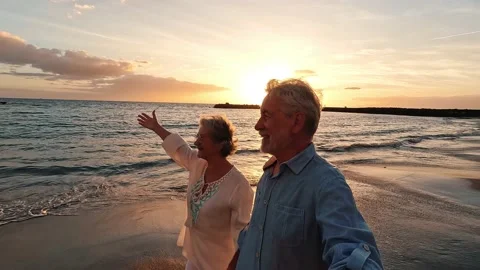 Portrait of two cute old persons having fun and enjoying together at the be.. 動画素材 224755069