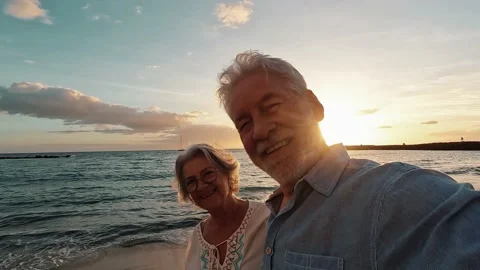 Portrait of two cute old persons having fun and enjoying together at the be.. 動画素材 224756311