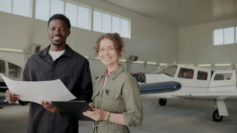 Portrait of Two Diverse Ground Technicians Smiling at Camera in Aviation Hangar Stock Footage 310849486