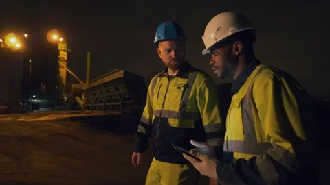 Portrait of two diverse industrial workers talking at construction site late at 스톡 동영상 124303883