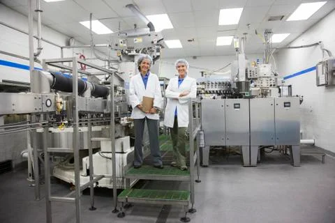 A portrait of two female technicians in the bottling area of a bottled water Stock Photos