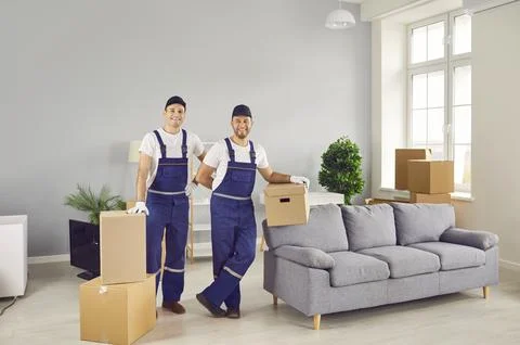 Portrait of two friendly workers of moving and delivery company who transport Stockfoto's
