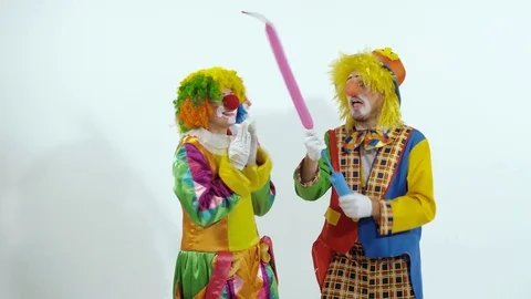 Portrait of two funny clowns making a figure of a dog out of a balloon Stock-Footage 70506962