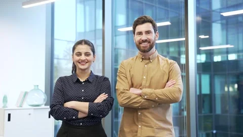 Portrait of two happy co-workers man and woman standing in modern office with Stock Footage 309011192