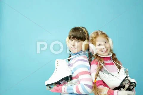 Portrait of two little girls with figure skates looking at camera and smiling Stock Photos